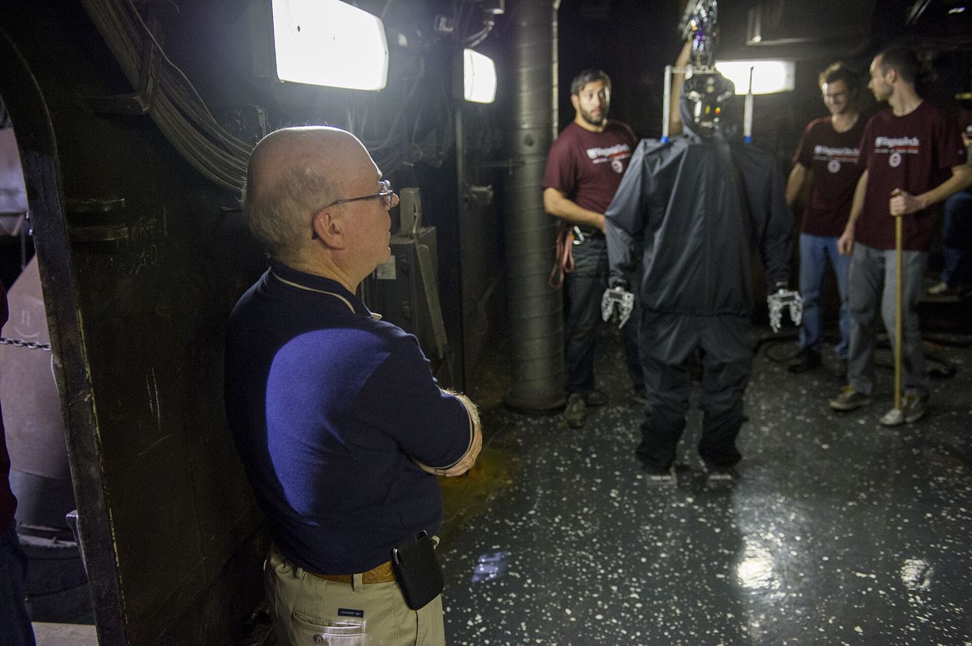 A humanoid robot undergoing balance and movement testing inside a bright research laboratory.